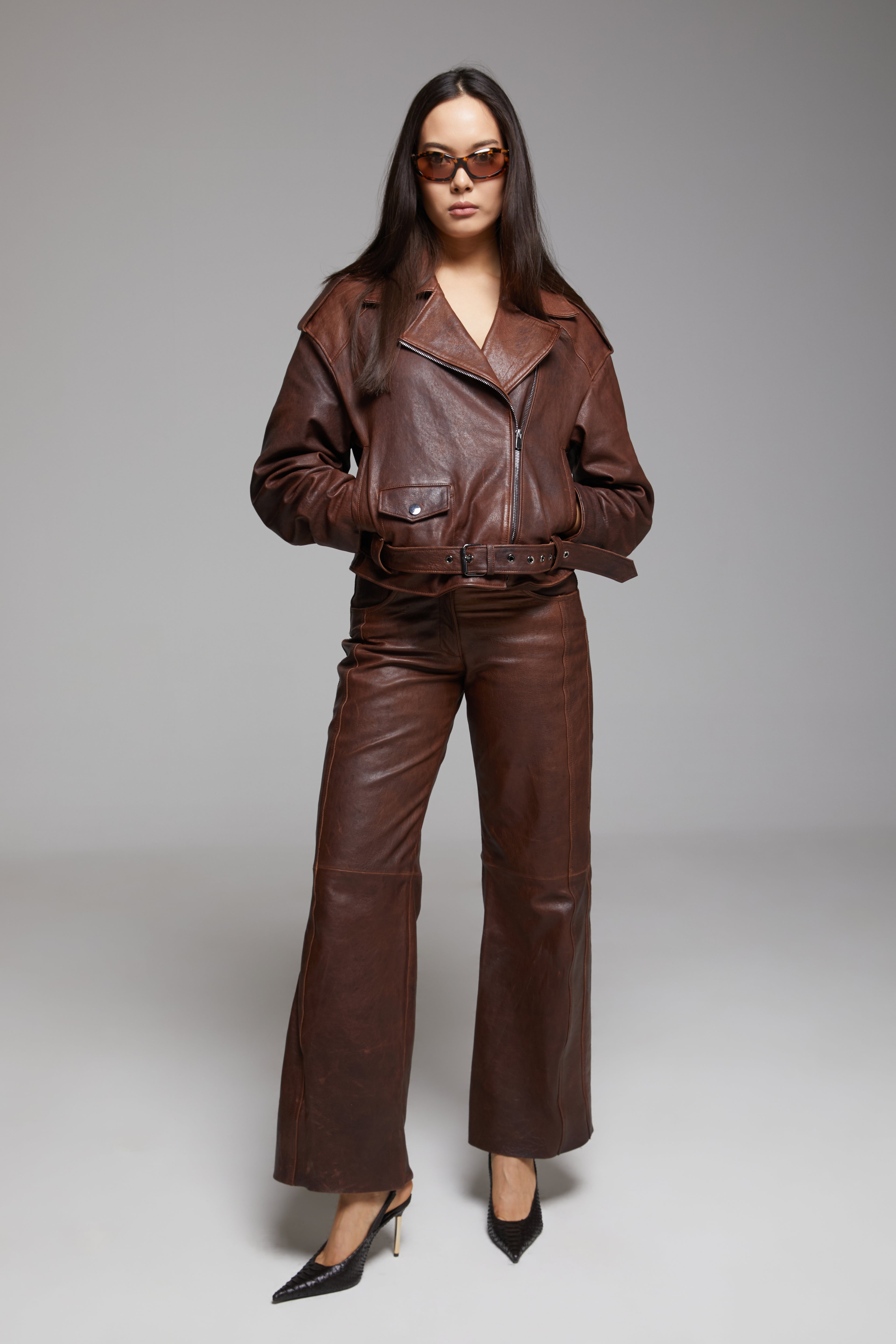 Black Rondo leather pants by BIENBIE, featuring a slim fit design and detailed stitching, shown on a model.