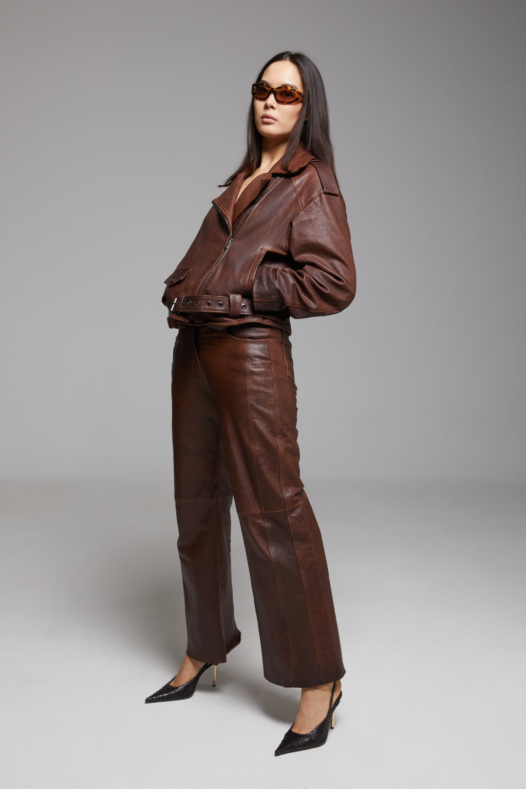 Black Rondo leather pants by BIENBIE with smooth, fitted design and detailed stitching, perfect for stylish casual wear.